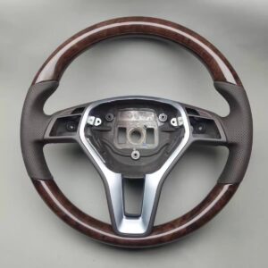 2013 mercedes cls 550(walnut wood trim at the 12 and 6 o'clock positions, an airbag cover with a black Mercedes logo,orange stitch on airbag perforated leather grips, and control buttons; black stitching)